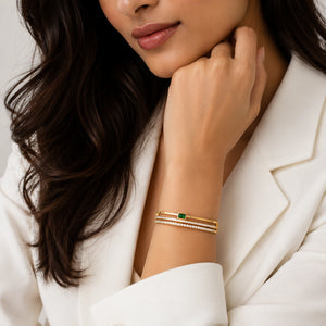 Gold green rectangular crystal bangle on a dark jewellery studio display