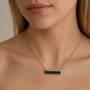 Gold green stone necklace styled in an elegant jewellery flat lay