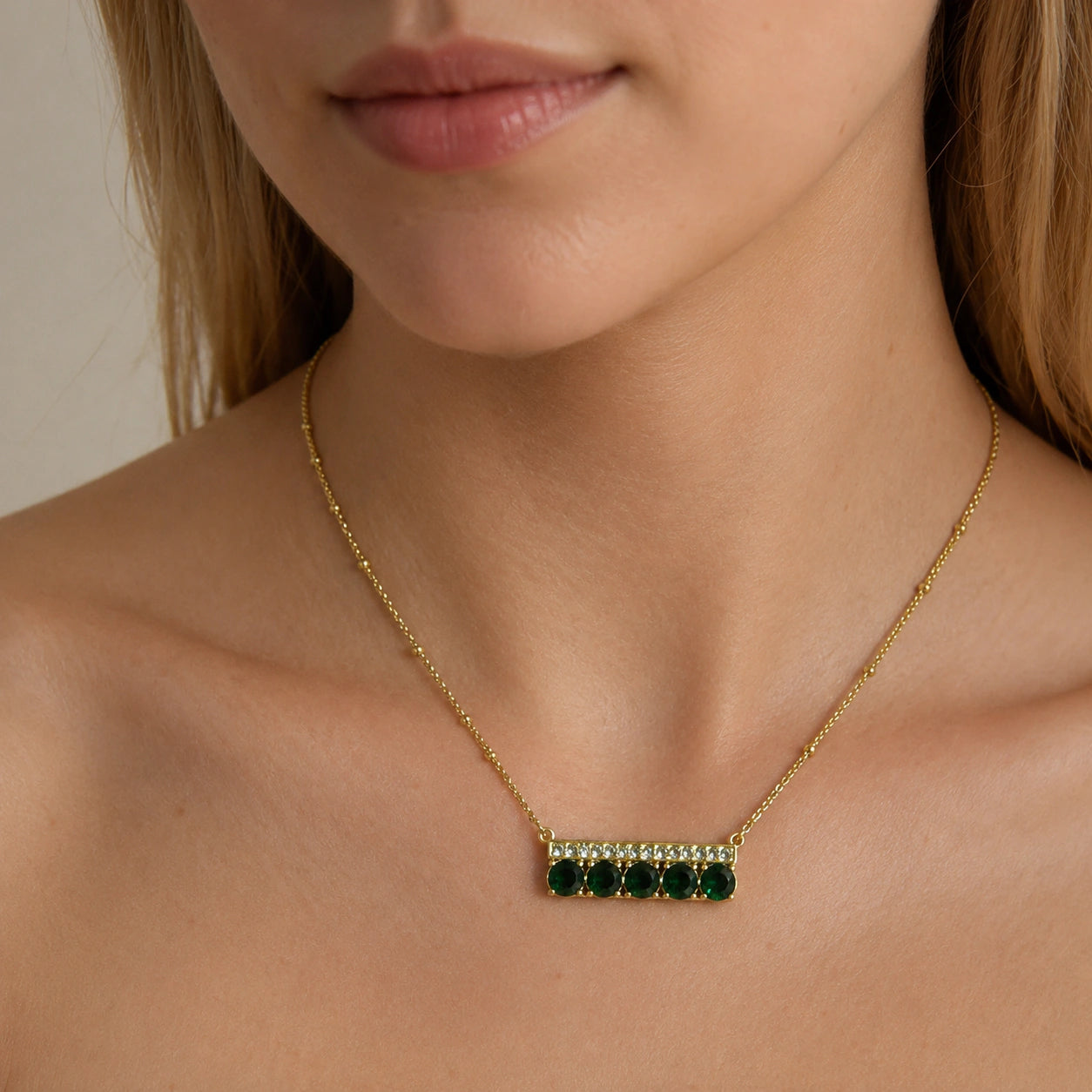 Gold green stone necklace styled in an elegant jewellery flat lay