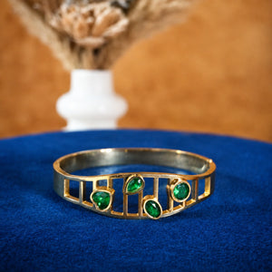 Gold green stone openwork kada styled in an elegant jewellery flat lay