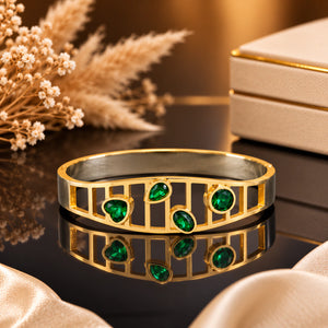 Close-up of green stones and gold openwork detailing