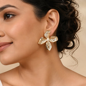 Gold hammered floral earrings styled in a modern jewellery flat lay