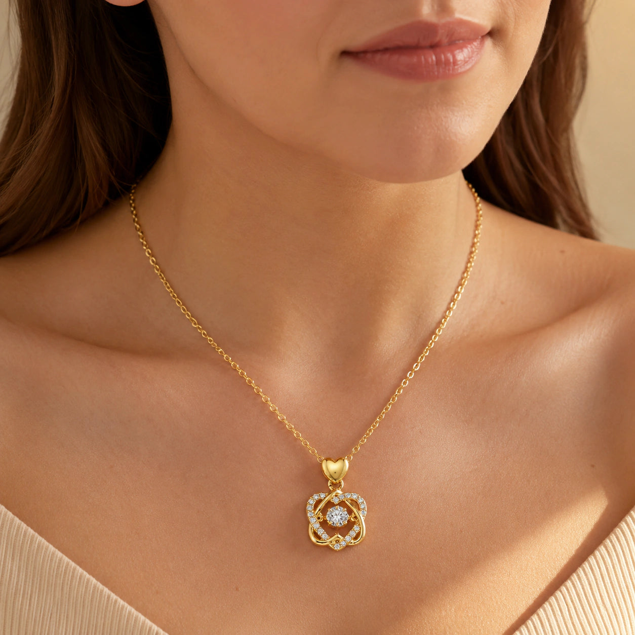 Angled view of the gold heart-bail crystal knot necklace