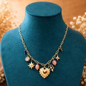 Angled view of the gold heart charm pink bead necklace