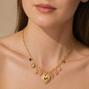 Gold heart charm necklace styled in an elegant jewellery flat lay