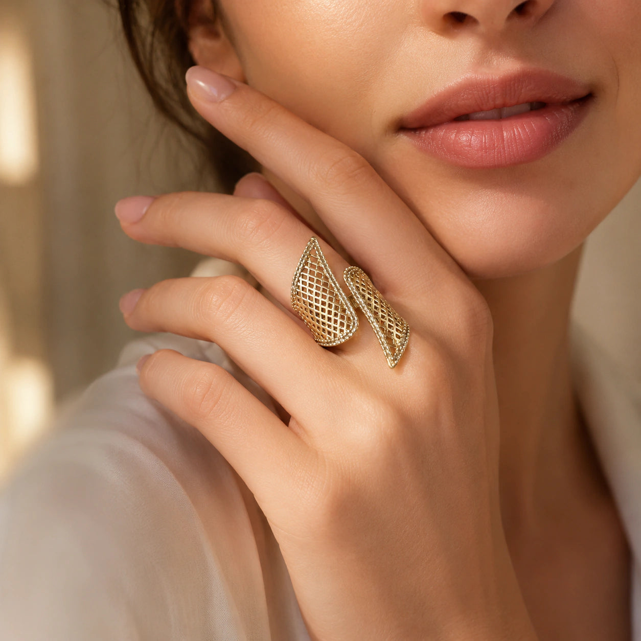 Gold lattice wing ring on a dark jewellery studio display