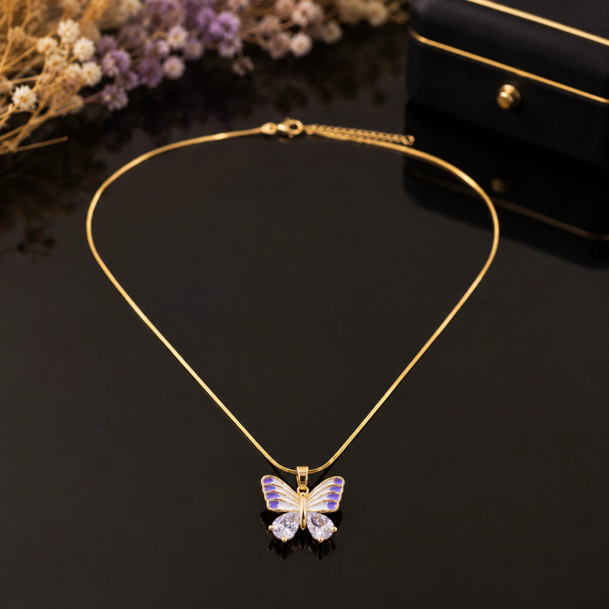 Gold lavender butterfly necklace styled in an elegant jewellery flat lay