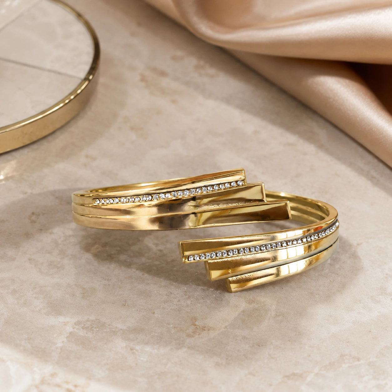 Gold layered crystal cuff styled in an elegant jewellery flat lay