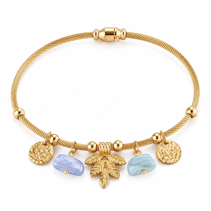 Gold leaf pastel charm bracelet on a dark jewellery studio display