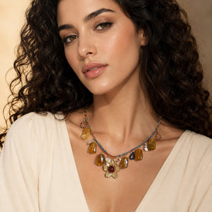 Gold multicolour flower charm necklace on a dark jewellery studio display