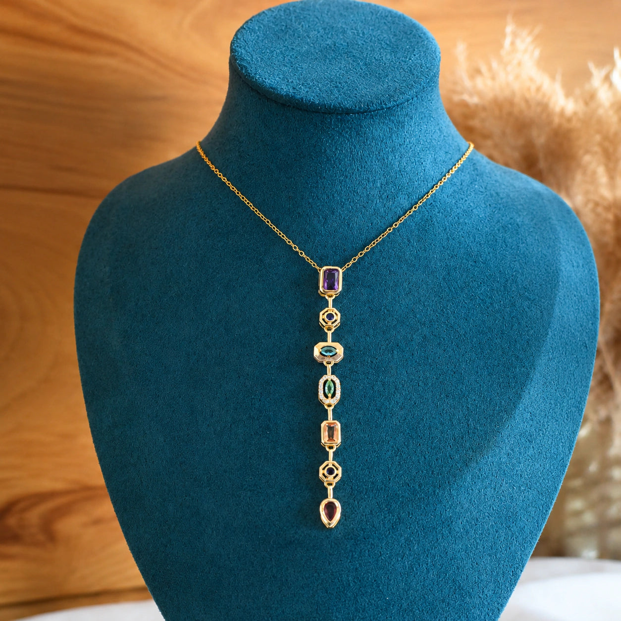 Angled view of the gold multicolour stone Y necklace