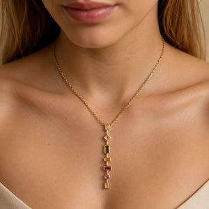 Gold multigem geometric Y necklace on a dark jewellery studio display