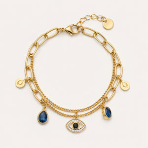 Gold navy blue evil-eye charm bracelet on a dark jewellery studio display