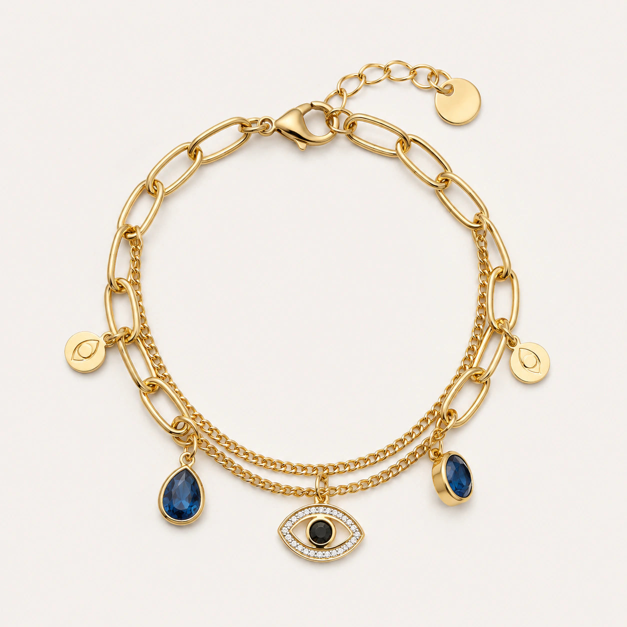Gold navy blue evil-eye charm bracelet on a dark jewellery studio display