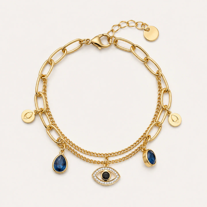 Gold navy blue evil-eye charm bracelet on a dark jewellery studio display