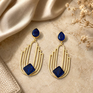 Gold navy chandelier earrings styled in a modern jewellery flat lay