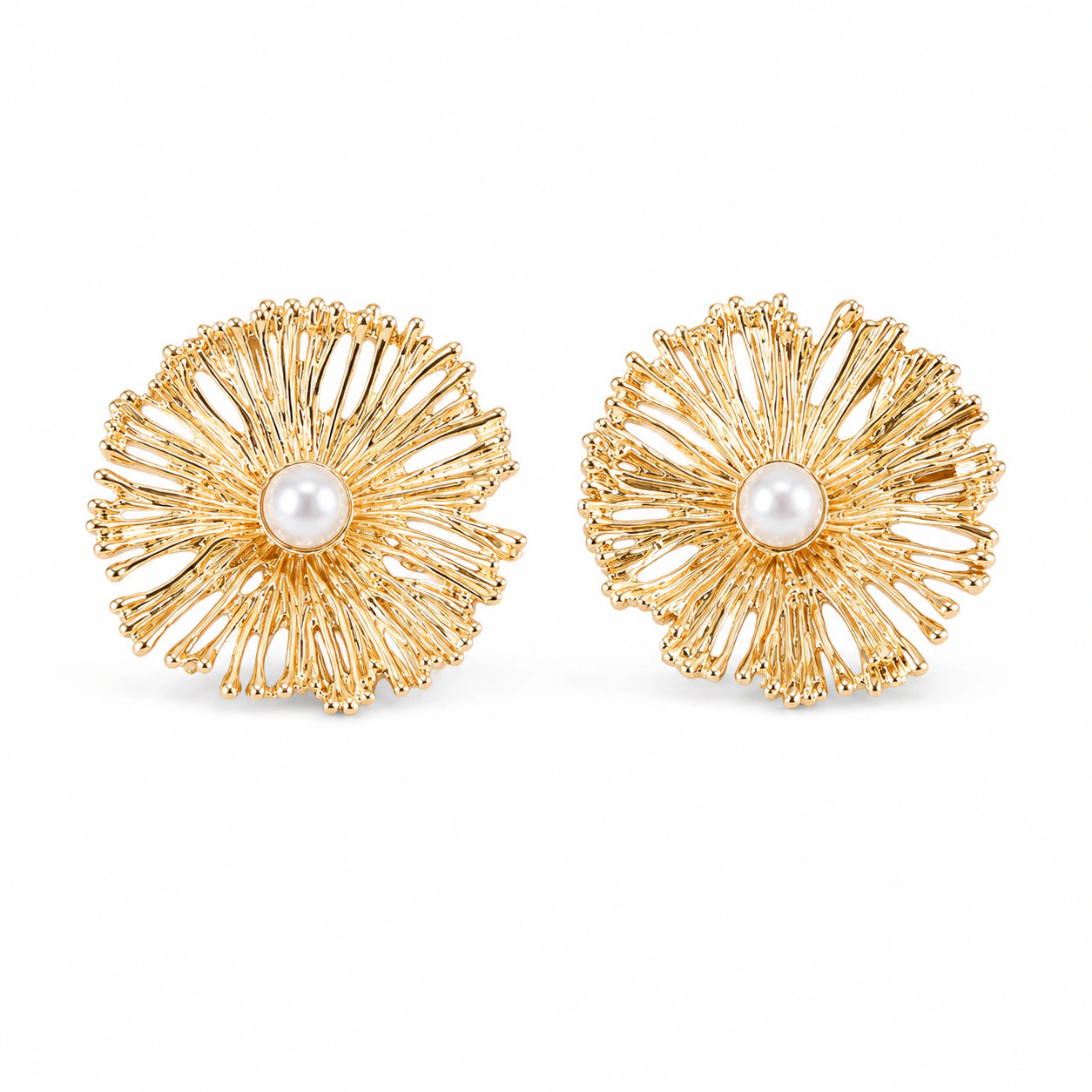 Gold sunburst pearl studs styled in an elegant jewellery flat lay