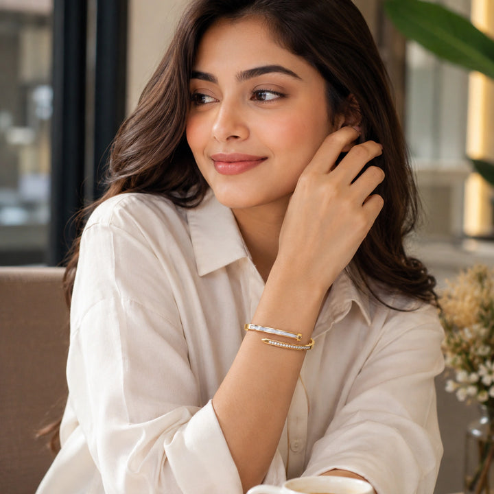 Gold pearl bar crystal bypass kada on a dark jewellery studio display