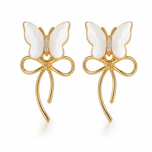 Angled view of gold pearl butterfly bow drop earrings