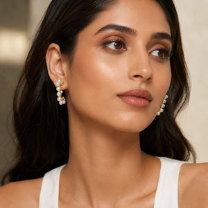 Gold pearl heart butterfly earring set on a dark jewellery studio display