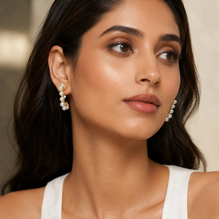 Gold pearl heart butterfly earring set on a dark jewellery studio display