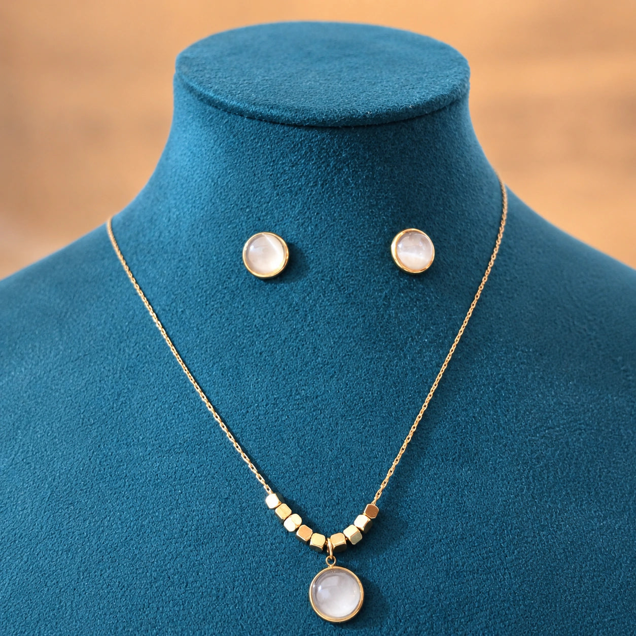 Angled view of the gold pearl round pendant necklace set