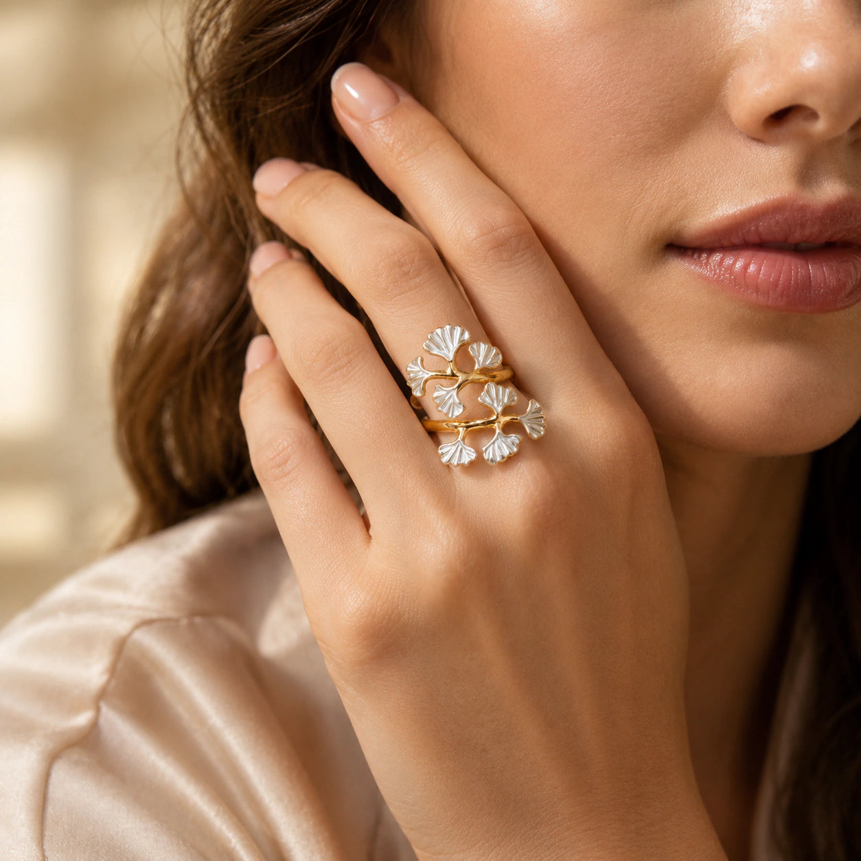 Angled view of the gold pearl-white ginkgo wrap ring
