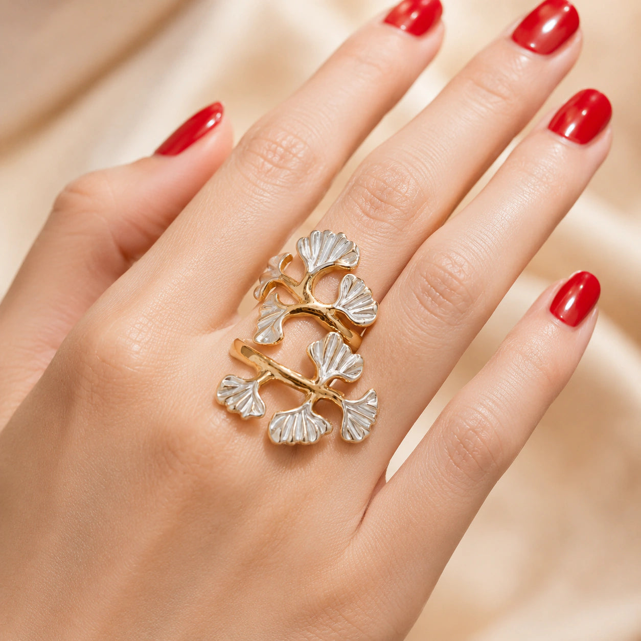 Gold pearl-white ginkgo ring styled in an elegant jewellery flat lay