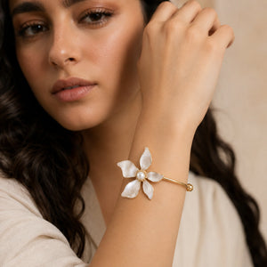 Gold pearly five-petal floral kada on a dark jewellery studio display