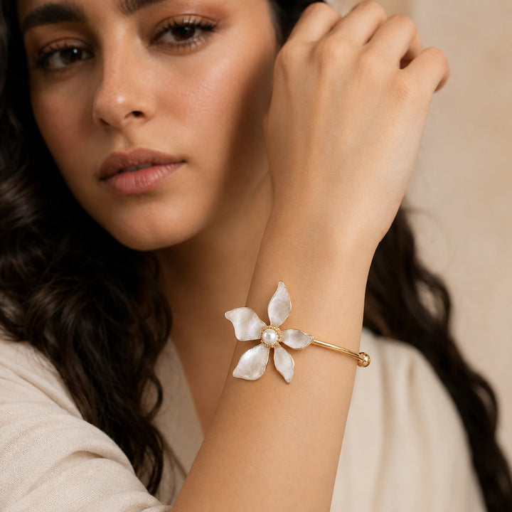 Gold pearly five-petal floral kada on a dark jewellery studio display