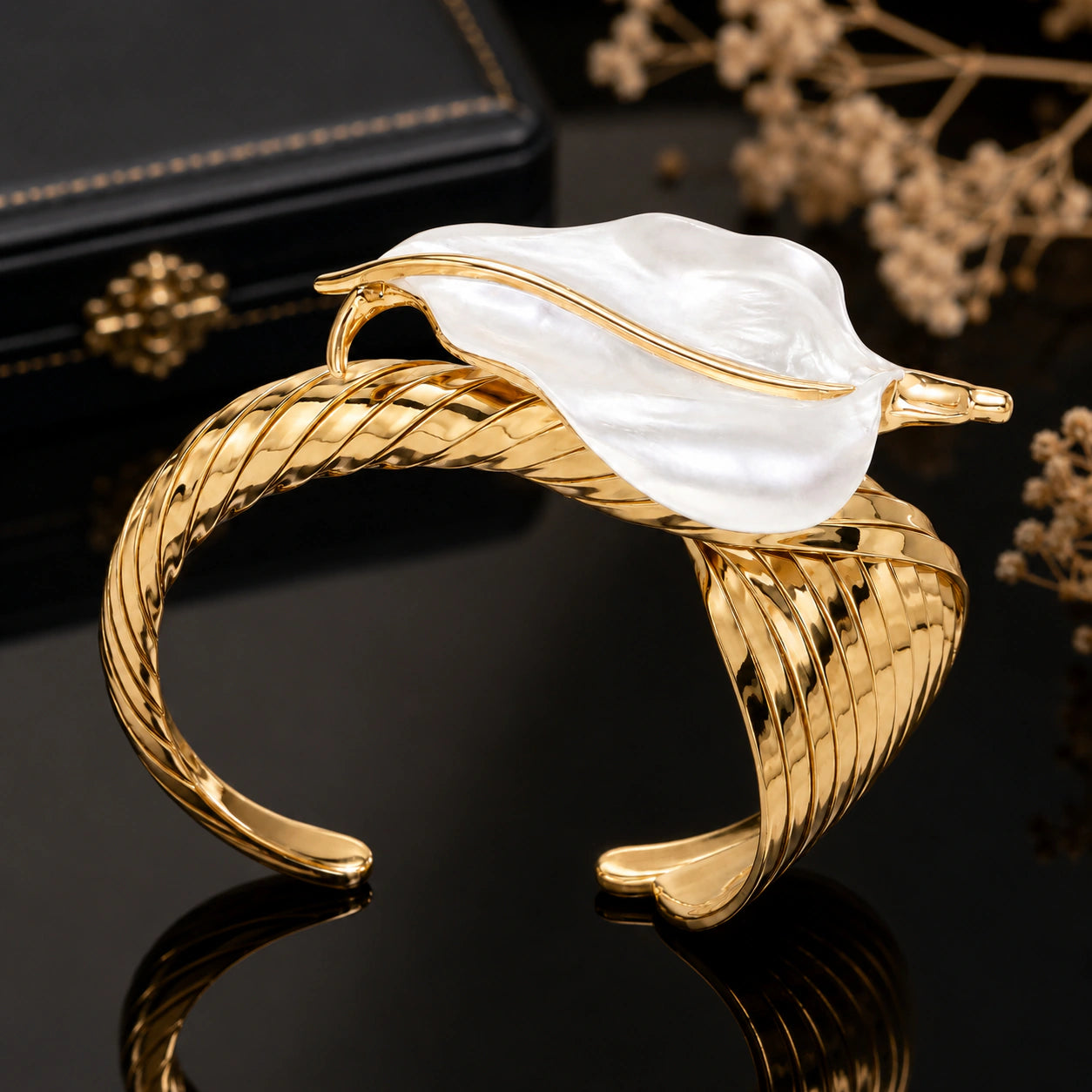 Angled view of the gold pearly sculptural leaf kada
