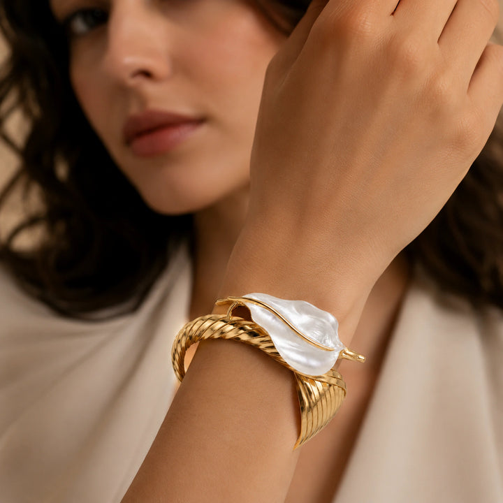 Gold pearly sculptural leaf kada on a dark jewellery studio display