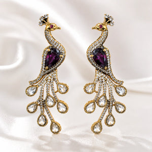 Purple peacock chandelier earrings styled in an elegant jewellery flat lay