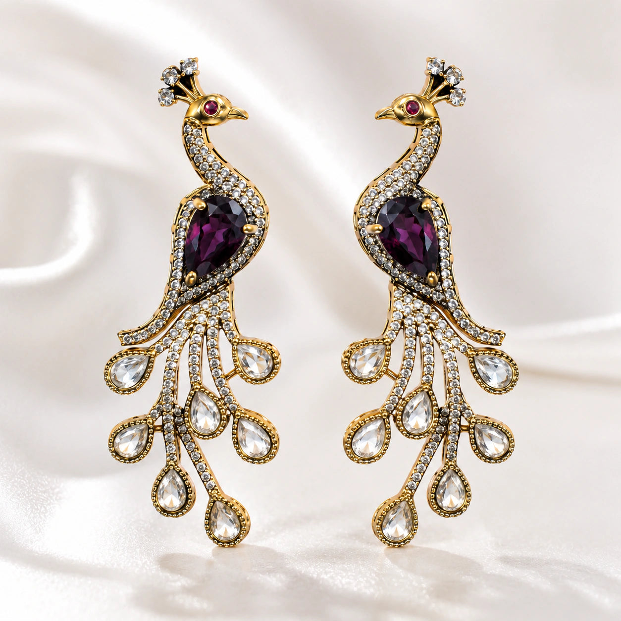 Purple peacock chandelier earrings styled in an elegant jewellery flat lay