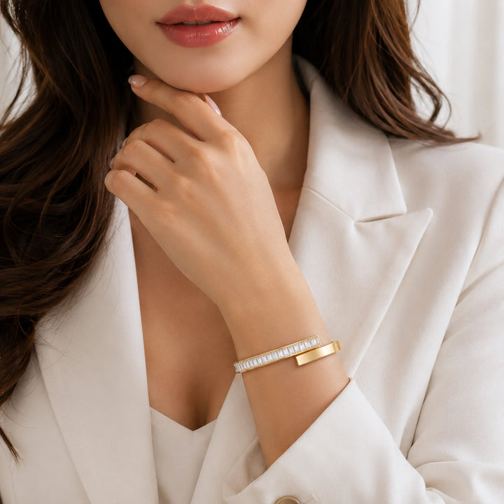 Gold rectangular crystal open cuff on a dark jewellery studio display