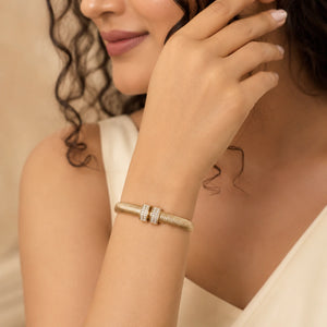 Gold ribbed coil crystal cuff on a dark jewellery studio display