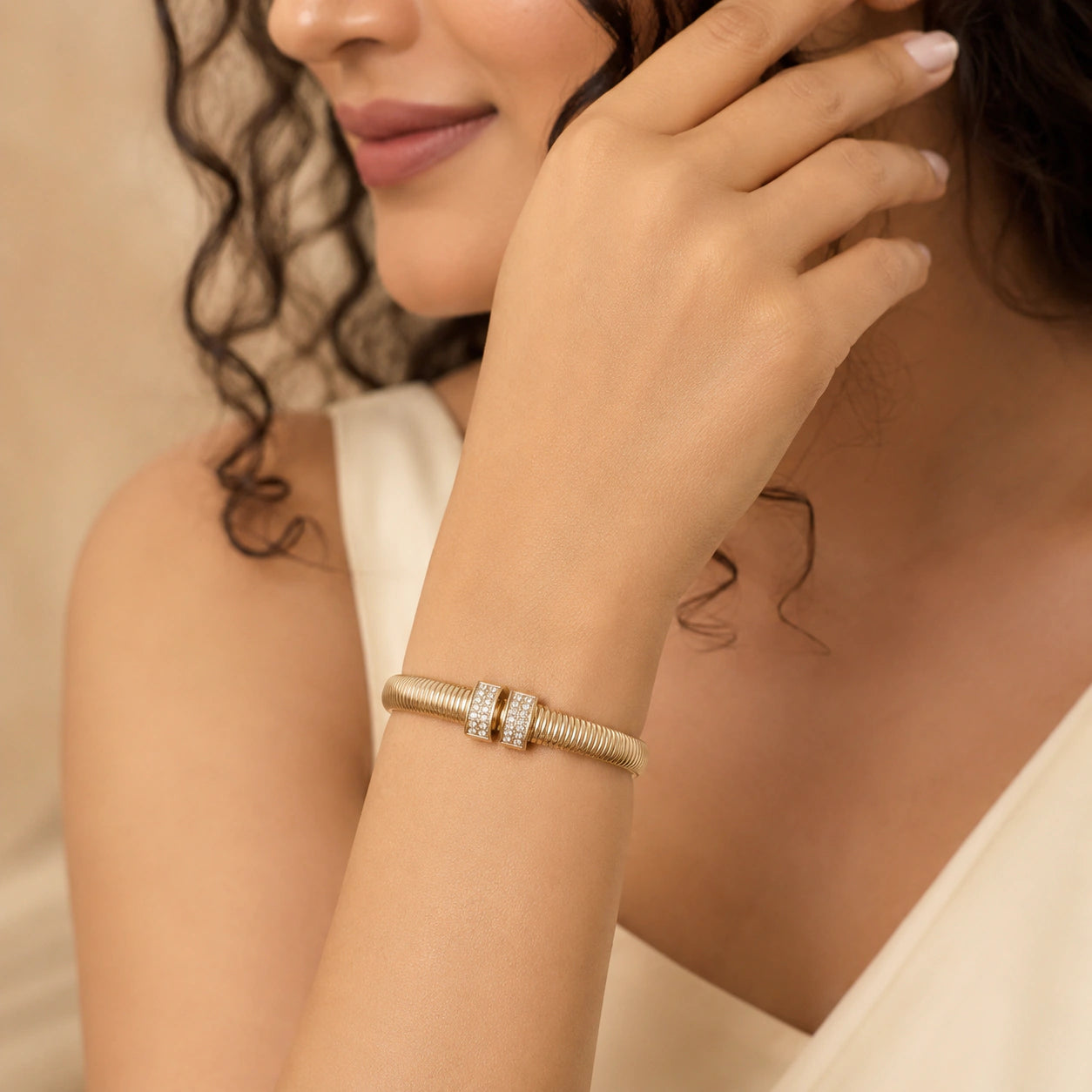 Gold ribbed coil crystal cuff on a dark jewellery studio display