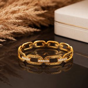 Angled view of the gold ribbed oval-link bracelet