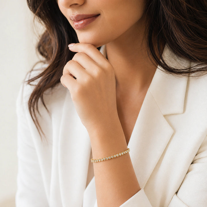 Gold round crystal tennis bangle on a dark jewellery studio display