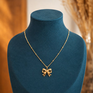 Alternate detail view of the gold sculpted bow charm