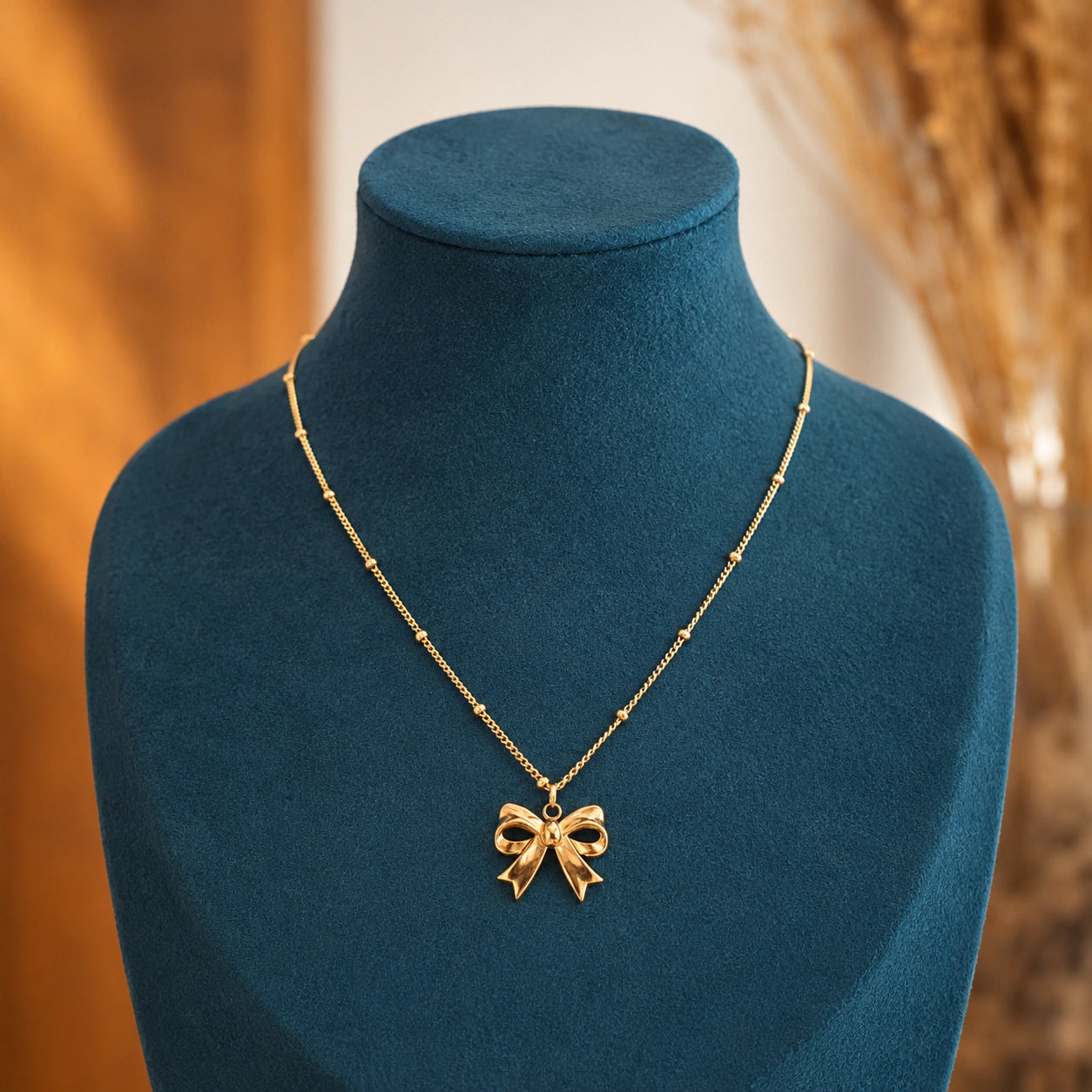 Alternate detail view of the gold sculpted bow charm