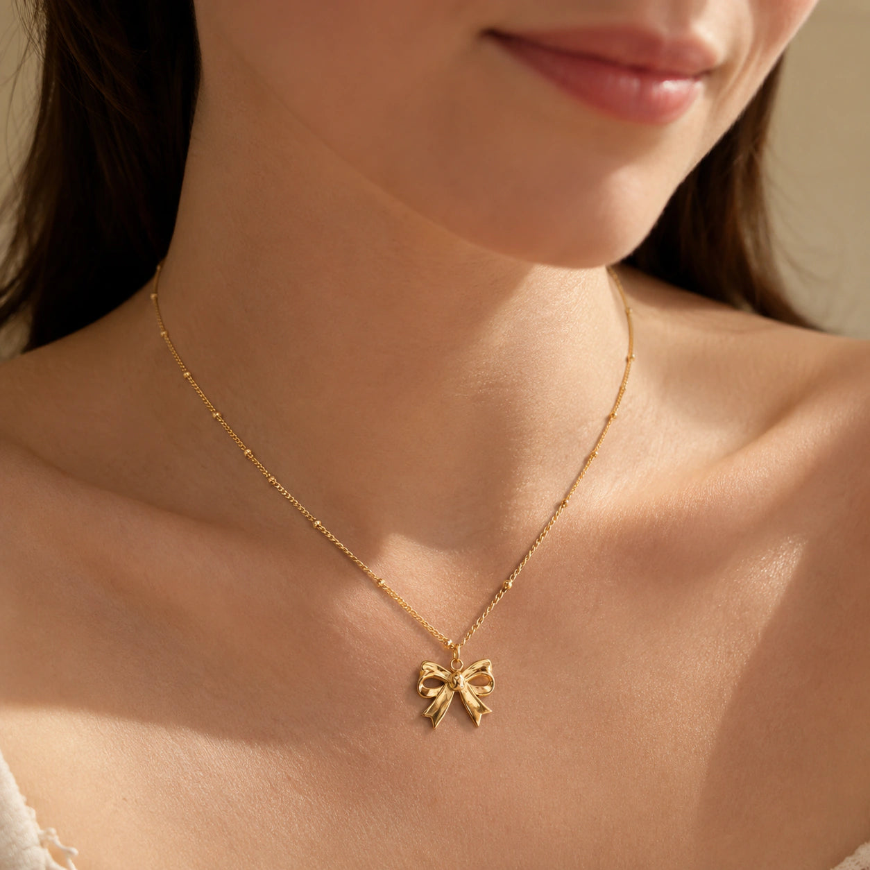 Close-up of the sculpted gold bow charm detailing