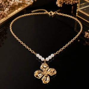 Gold sculpted floral necklace styled in an elegant jewellery flat lay