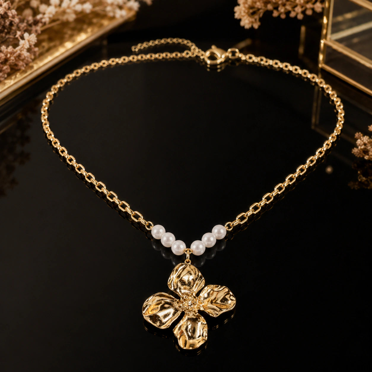 Gold sculpted floral necklace styled in an elegant jewellery flat lay