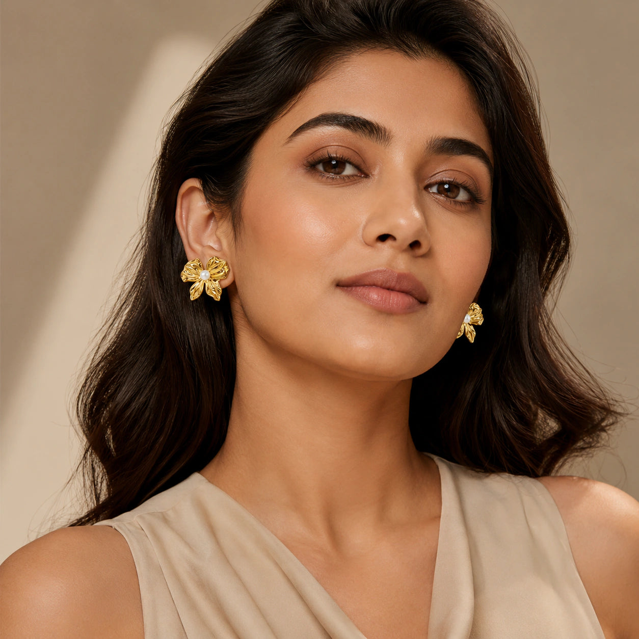 Angled view of gold sculpted pearl-style flower studs