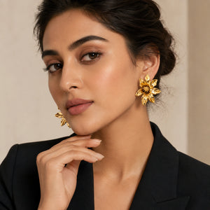 Gold sculptural bloom studs on a dark jewellery studio display