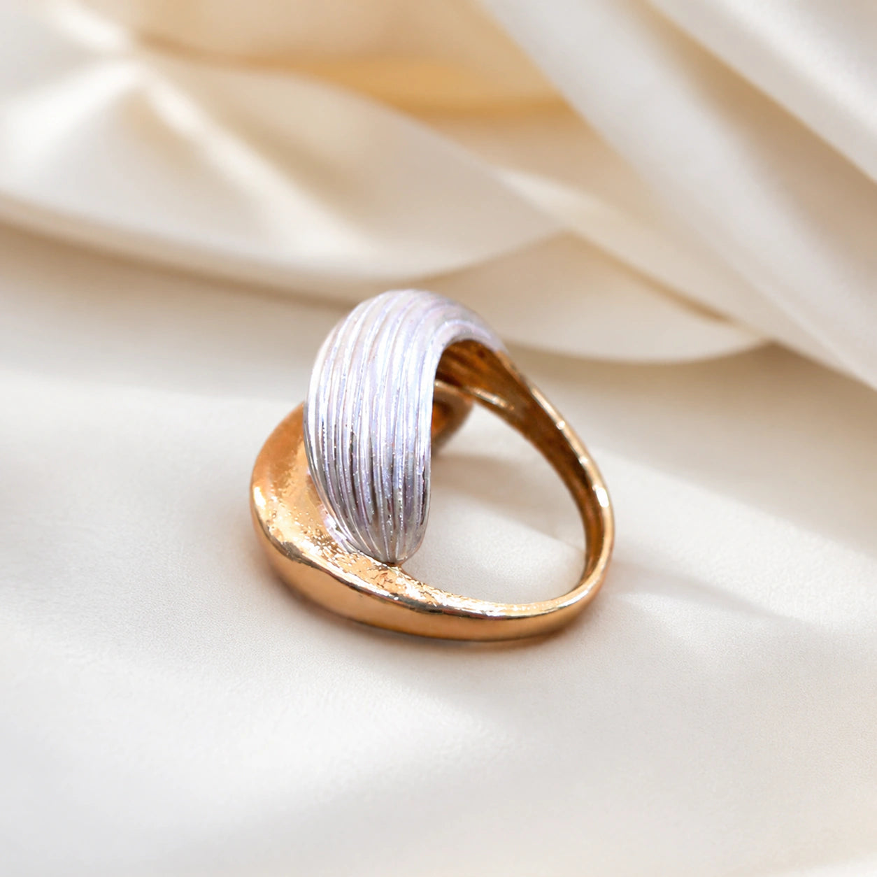 Angled view of the gold and silver ribbed wrap ring
