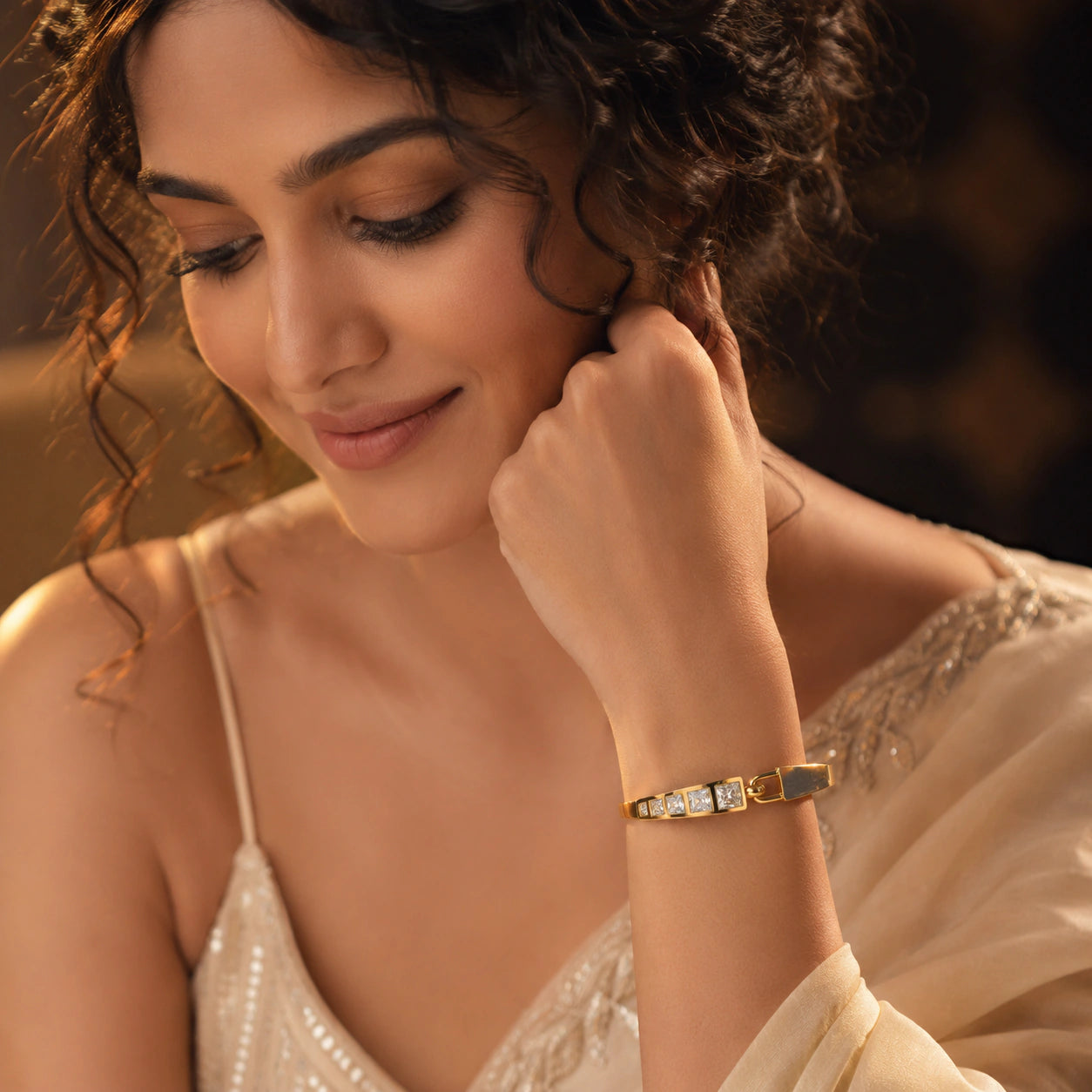 Gold square crystal-bar hinged kada on a dark jewellery studio display