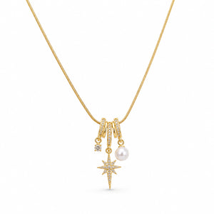 Angled view of the gold starburst pearl charm necklace