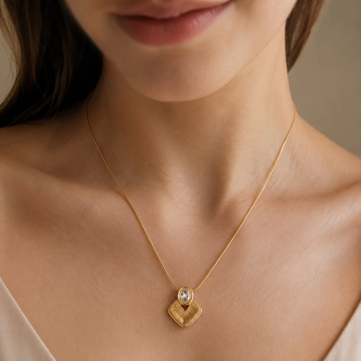 Close-up of the oval crystal and sunburst pendant detailing